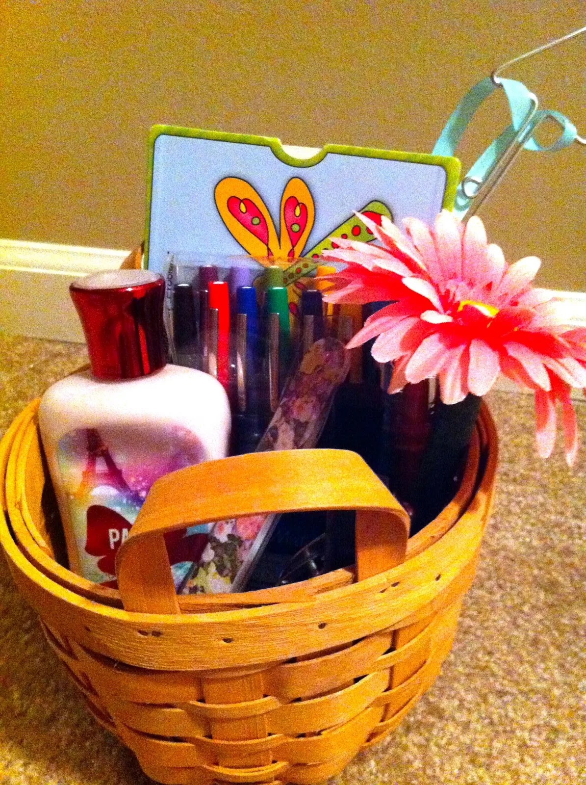 Basket with lotion, pens, and a flower